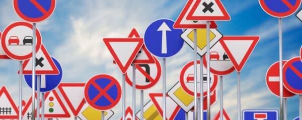 A plethora of various road and traffic signs layered on top of eachother